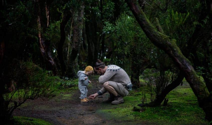 Father with cute little child in mystic green woods